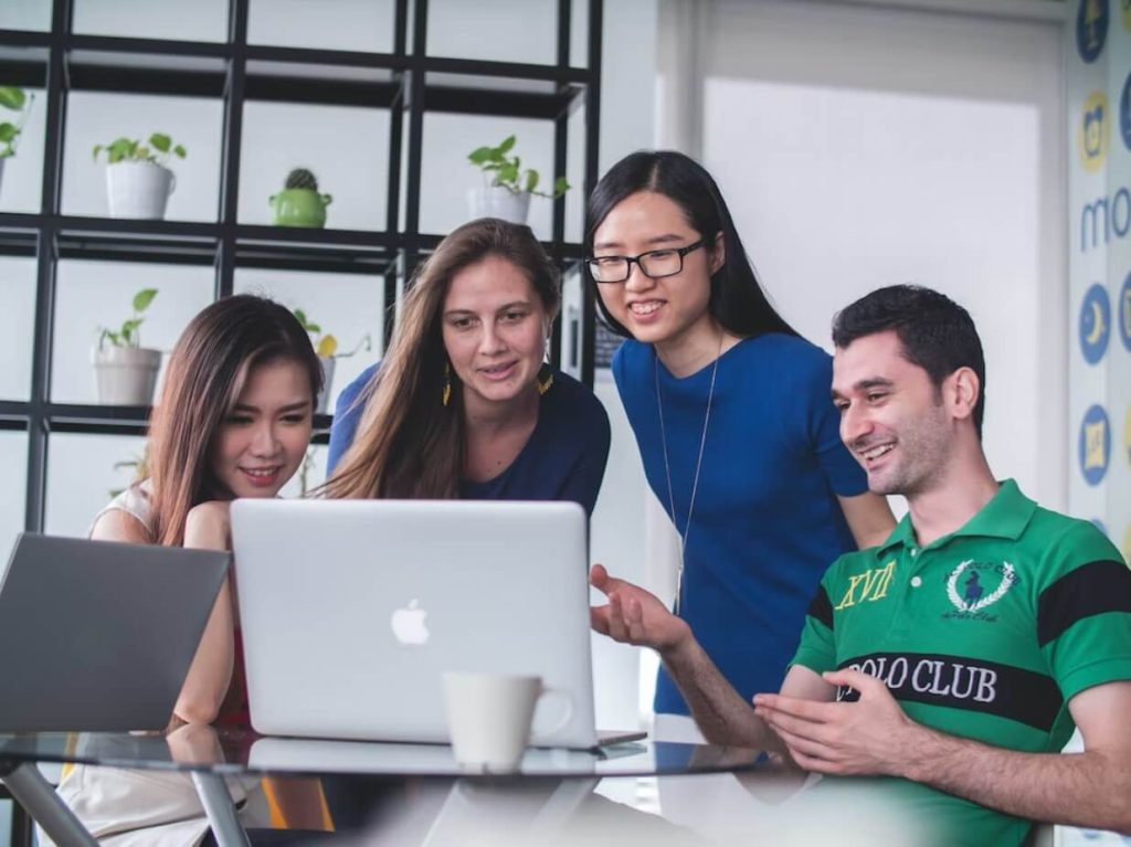 four people discussing in front of a laptop pre seed funding investors