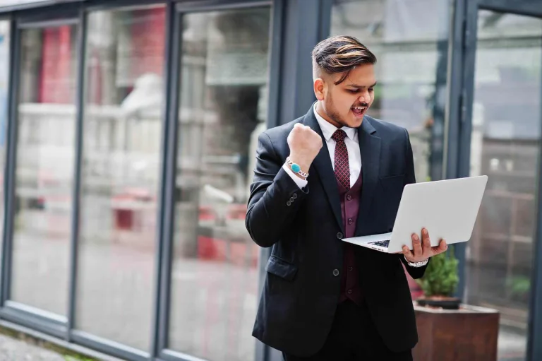 happy man walking with his laptop software development and consulting services 1