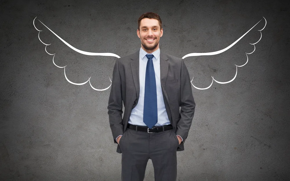 Angel Investor photo - Happy businessman with angel wings over gray background