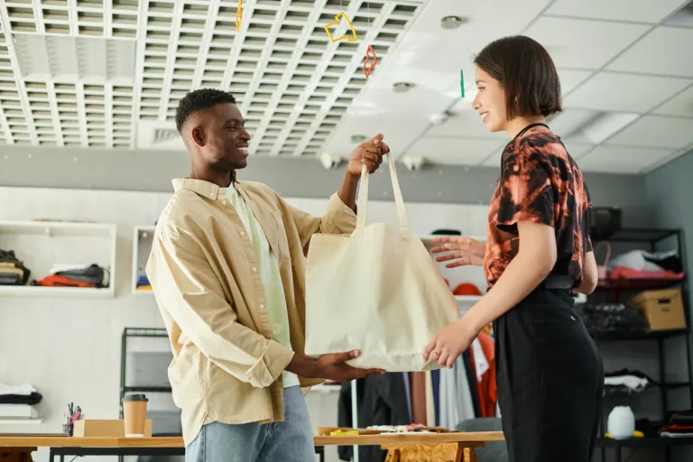 Happy african american designer holding a sustainable canvas shopping bag